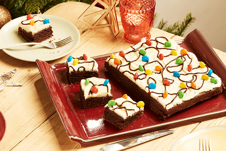 Christmas light brownies topped with cream & sugar coated chocolate beans served on a red tray