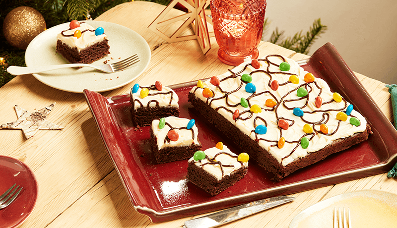 Christmas light brownies topped with cream & sugar coated chocolate beans served on a red tray